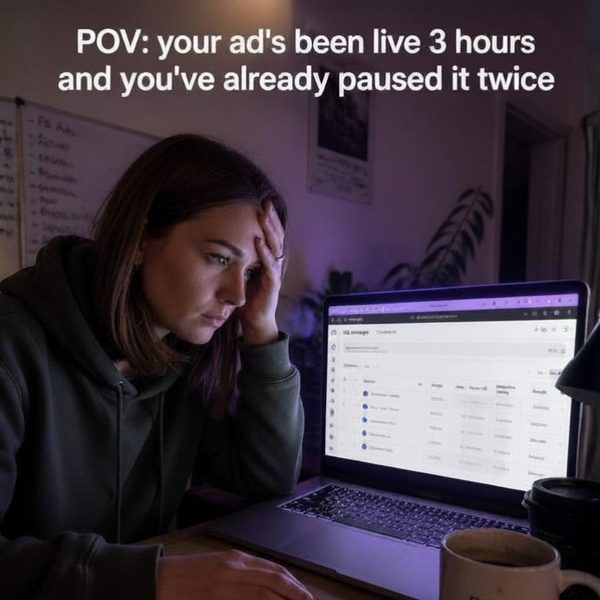 Photographer at a laptop late at night, head in hand, staring at an ads dashboard