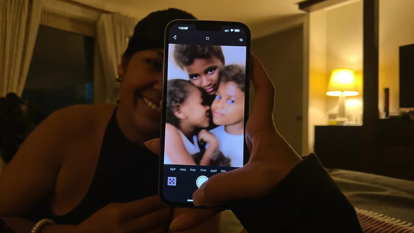 A woman at home smiling at a portrait photograph on her phone