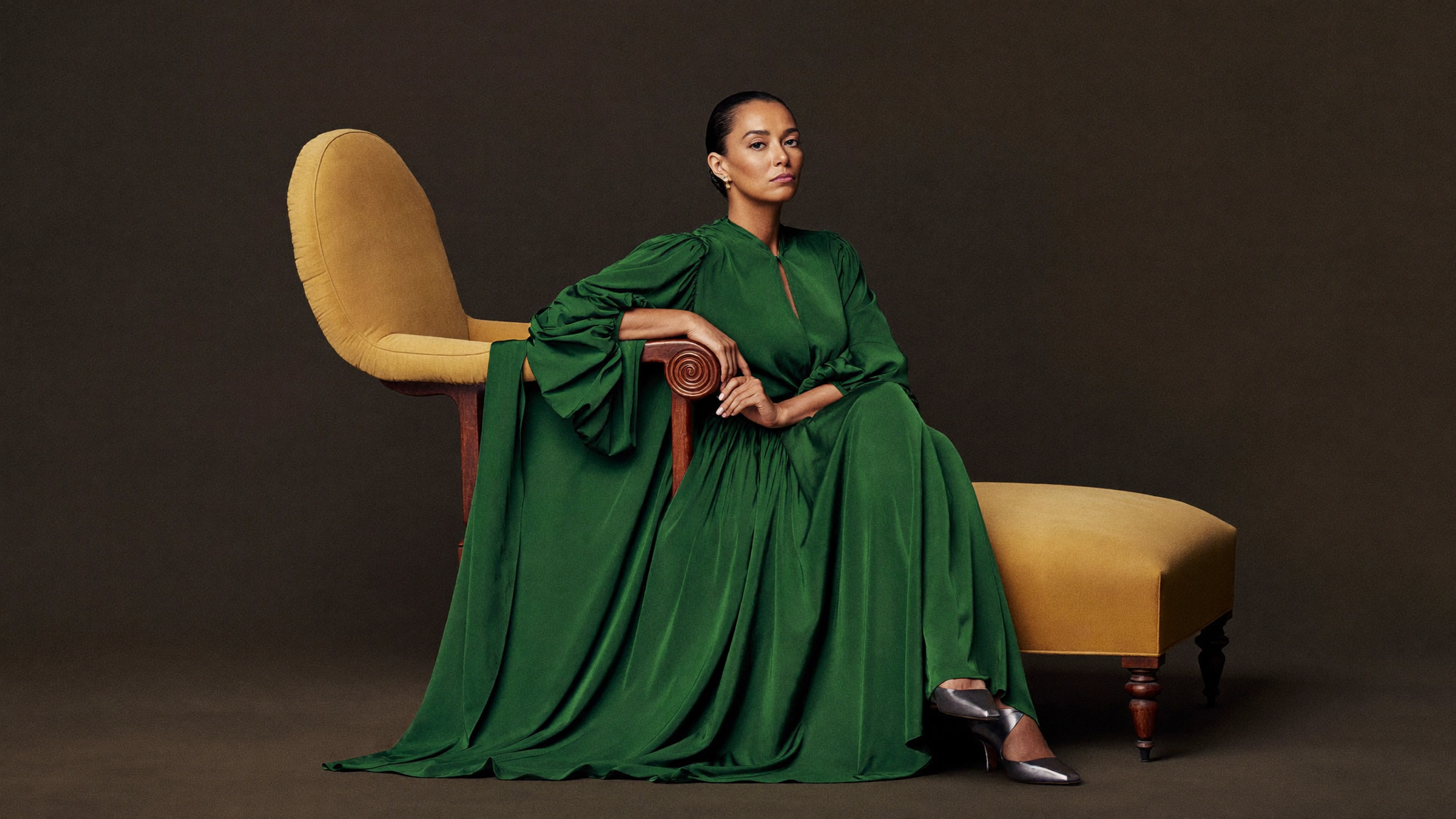 An elegant woman in an emerald gown in a fine-art studio portrait with warm painterly light