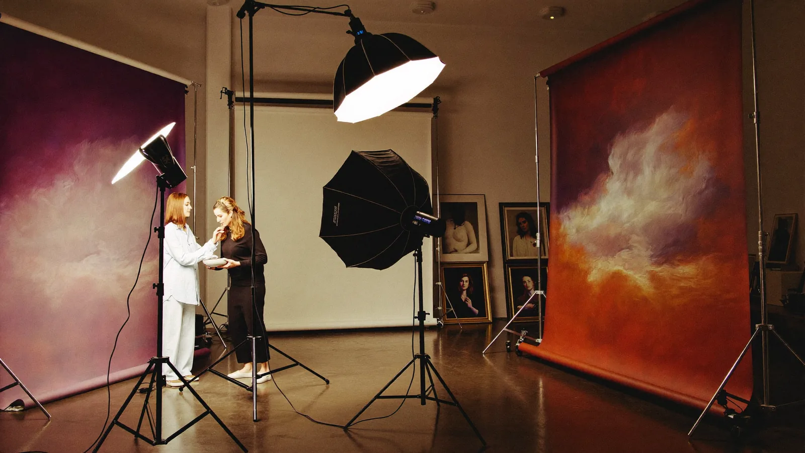 A luxury portrait studio production day: softboxes, painterly backdrops and gallery-framed portraits